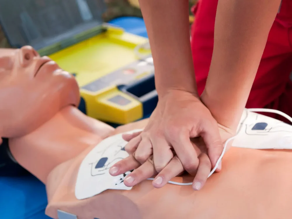 Practicing defibrillator CPR procedure on a dummy